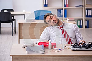 Young male employee suffering at workplace