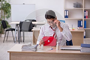 Young male employee suffering at workplace