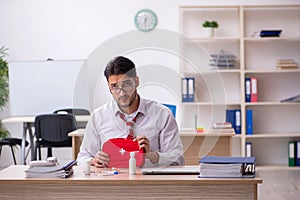 Young male employee suffering at workplace