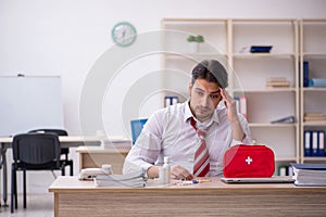 Young male employee suffering at workplace