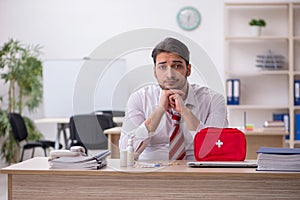 Young male employee suffering at workplace