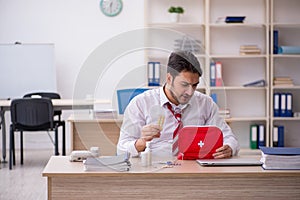 Young male employee suffering at workplace