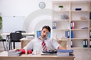 Young male employee suffering at workplace