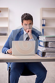 Young male employee and too much work in the office