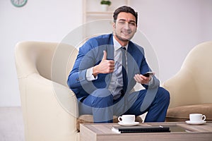 Young male employee waiting for business meeting