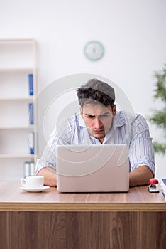 Young male employee working in the office