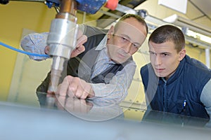 Young male engineer in factory using milling machine