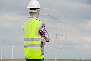 Young male engineer in green vest and helmet