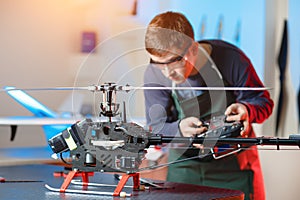 Young Male Engineer or Technician with Remote Control in His Hands Programs Drone. Focus on Drone.