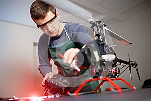 Young Male Engineer or Technician with Remote Control in His Hands Programs Drone.
