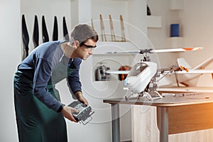 Young Male Engineer or Technician with Remote Control in His Hands Programs Drone.