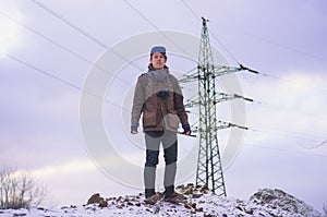 Young male engineer worker on background of high-voltage mast