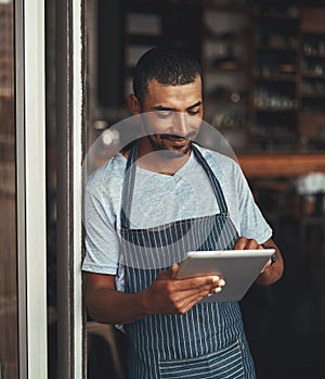 Young male entrepreneur using digital tablet at the cafe entranc