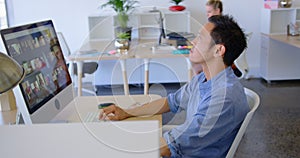 Young male executive working on desktop pc at desk 4k