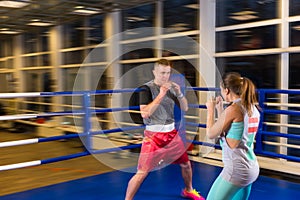 Young male and female in action practicing boxing