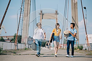 Young male and female buskers carrying instruments on sunny