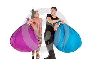 Young male and female fighting with beanbag chairs