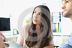 Young male and female interns look up at boss in office