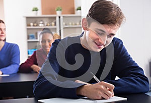 young male and female students following explanations of teacher