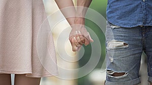 Young male and female taking each other by hand and letting go, saying good bye