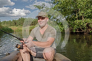 Young male fisherman in a boat with a fishing rod