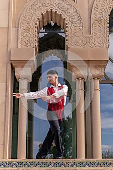 young male flamenco dancer in white shirt and red mantillo dancing photo