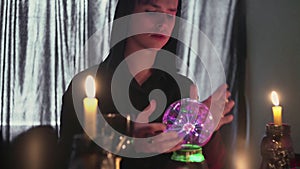 Young male fortune teller performing ritual with crystal ball foreseeing future