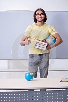 Young male geography teacher in front of whiteboard