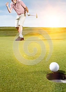 Young male golfer celebrating birdie putt