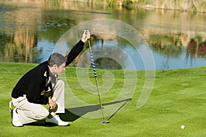 Young Male Golfer Lining Up Putt