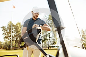 Young male golfer looking at a wristwatch