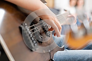 Young male hands playing electric guitar. Concept of learning to play a musical instrument