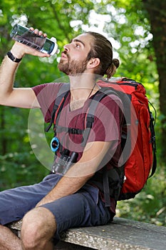 young male hiker drinking water photo