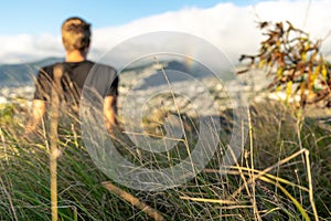 Young male hiker sitting on the summit of Diamond Head Crater in Honolulu on the Island of Oahu, Hawaii