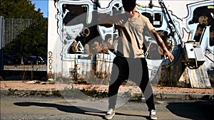 Young male hip-hop dancer dancing outside