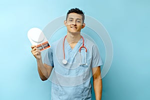 Young male Hispanic doctor holding a scale to measure food, a nutritionist concept.