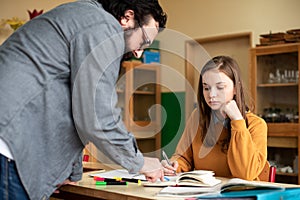 Young male hispanic teacher helping his student in chemistry class. Education, Tutoring.