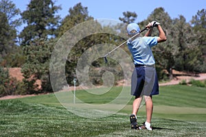 Young male hitting golf ball