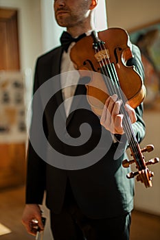 Young male holding violin in hands