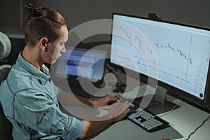 Young male IT industry freelancer working late at night