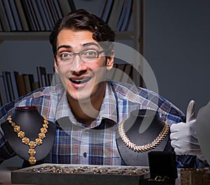 Young male jeweller working at night in his workshop