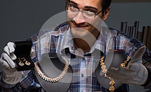 Young male jeweller working at night in his workshop