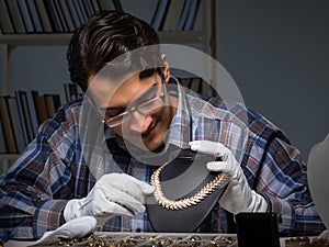 Young male jeweller working at night in his workshop