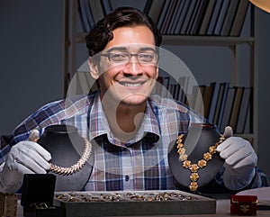 The young male jeweller working at night in his workshop