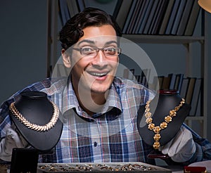 Young male jeweller working at night in his workshop