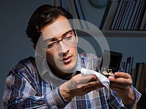 Young male jeweller working at night in his workshop