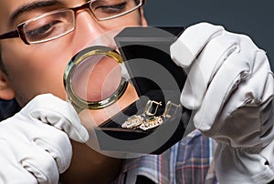 Young male jeweller working at night in his workshop