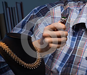 Young male jeweller working at night in his workshop