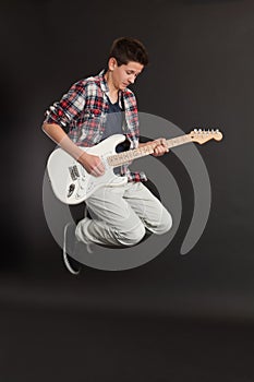 Young male jumping with guitar