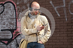 Young male in khaki listen to music from his phone